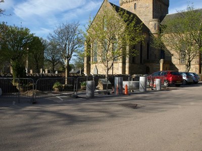 Barrier protected site of granite bollards and seat at Mercat Cross