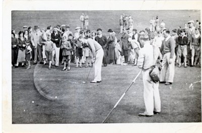 Golfers putting with large number of spectators