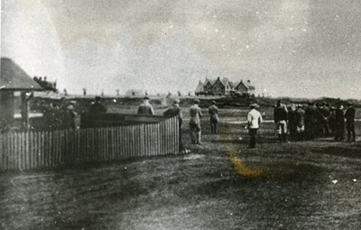 The old clubhouse with assembled golfers