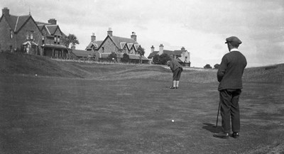 Golfing pair with Grange Road houses in background