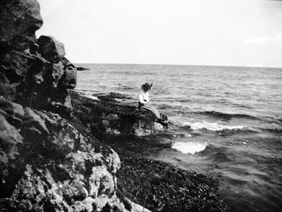A lady sitting on the rocks at Dornoch beach