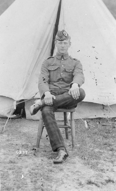 Young soldier seated in front of bell tent
