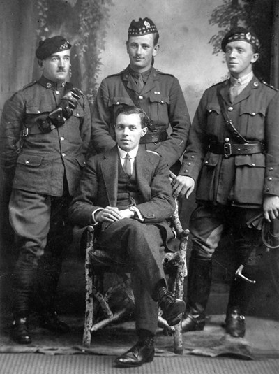 Studio portrait of three soldiers and man in suit