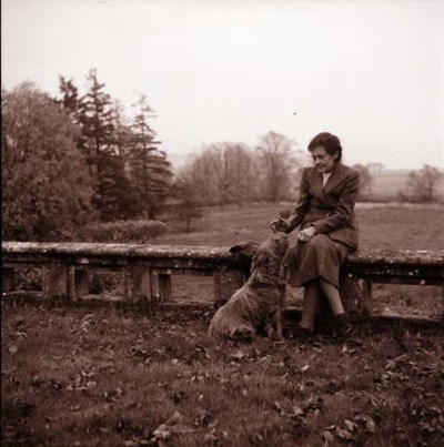 Lady with dog in large garden grounds