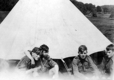 Scouts sitting outside bell tent