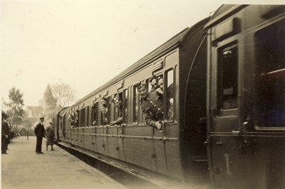 Train at Dornoch Station, with soldiers looking out of the windows